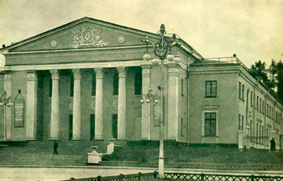 На фасадній частині будівлі видно високі круглі колони і без особливих надмірностей ліпні прикраси